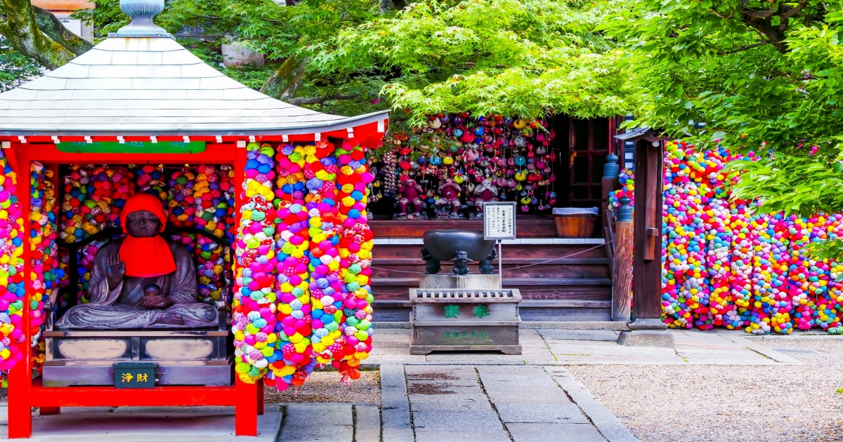 京都・八坂庚申堂の境内に吊るされた色とりどりのくくり猿と本堂の様子