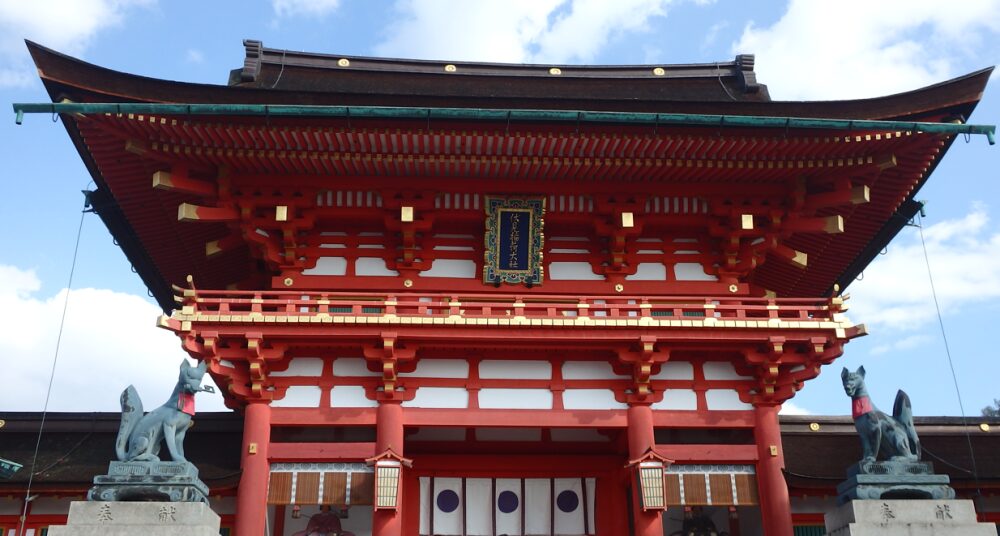 伏見稲荷大社の鮮やかな朱色の楼門を正面から撮影した写真。